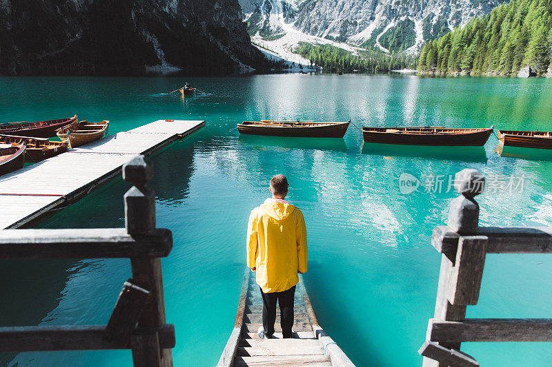 身穿雨衣的男人在Dolomites阿尔卑斯山的Lago Di braes享受夏天的早晨